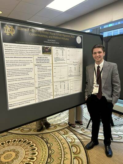 Kennedy Scholar Jacob Sherer stands next to his presentation.