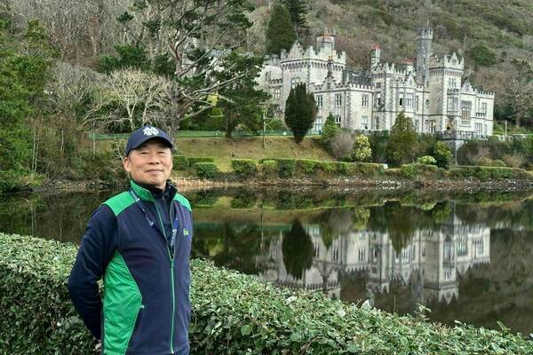 Cheng Wang stands in front of Kylemore Abbey during Winter Writing Session