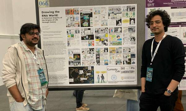 Saurja and Argha stand next to their comic book presentation.