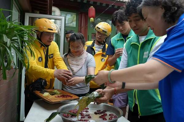 GPE students learning to make traditional zongzi from food delivery riders and community workers