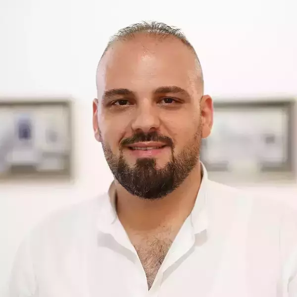 Fadi Nweiser. Smiling man with a dark full beard, receding hairline, and an open white collared shirt.