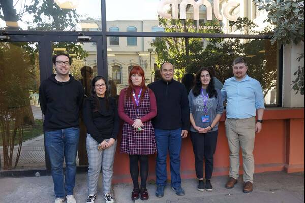 Three men and three women smile in front of the Advanced Mining Technology Center.