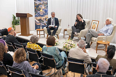 Panelists discuss at a University of Notre Dame event with a backdrop of the Main Building.